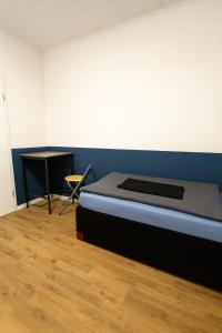 a bedroom with a bed and a table in it at Moderne 3-Zimmer-Ferienwohnung in Emersleben in Halberstadt