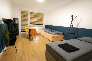 a bedroom with two beds and a table and a window at Moderne 3-Zimmer-Ferienwohnung in Emersleben in Halberstadt