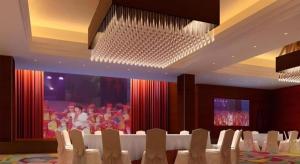 a banquet hall with white chairs and a crowd of people at Wyndham Garden Hotel in Lingshui