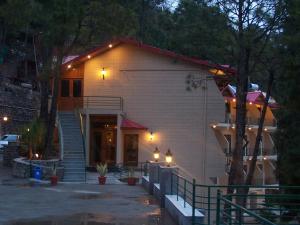 a house with lights on the side of it at Forest Ville Hotel & Resort in Kasauli