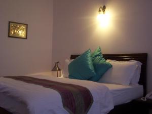 a bedroom with a bed with blue and white pillows at Forest Ville Hotel & Resort in Kasauli