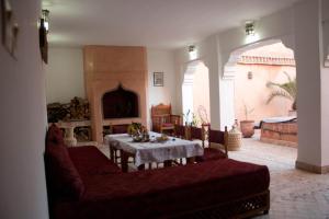 un soggiorno con divano rosso e tavolo di Riad Tayba a Fes