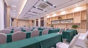 a conference room with green tables and white chairs at Lavande Hotel Ji'nan Railway Station Long Distance Bus Terminal in Jinan