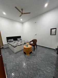 a room with a bed and a table and a chair at Kamal Kishori Dham in Barsāna