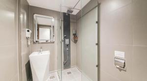 a bathroom with a shower and a sink at Sun Land Hotel Jeju in Jeju