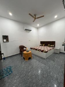 a bedroom with a bed and a chair and a table at Kamal Kishori Dham in Barsāna