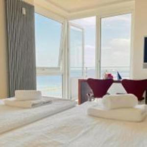 a bedroom with a bed and a large window at Penthaus Horizont mit Meerblick in Lübeck