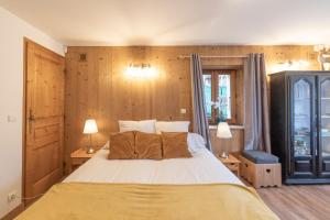 La Tanière في سان جيرفيه ليه بان: غرفة نوم بسرير كبير وبجدران خشبية