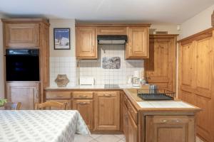 La Tanière في سان جيرفيه ليه بان: مطبخ مع خزائن خشبية وطاولة عمل