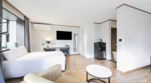 a hotel room with a bed and a tv at Sun Land Hotel Jeju in Jeju