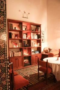 un salon avec une étagère remplie de livres dans l'établissement Riad Tayba, à Fès