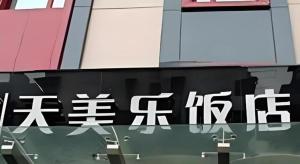 Tomolo Hotel Wuzhan Branch في ووهان: علامة على جانب مبنى فيه كتابة اسيوية