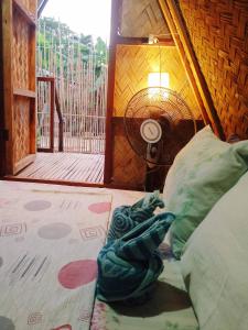 a bedroom with a bed with a pillow and a fan at Amwani Beach Camp in El Nido
