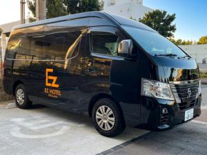 a black van parked in a parking lot at EZ HOTEL Kansai Airport Seaside in Izumi-Sano