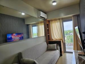 a living room with a couch and a tv at Avida Abreeza 1bedroom with balcony in Davao City