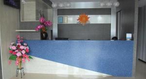 a blue counter in a lobby with flowers in at Sunshine Inn in Bintulu