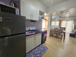 a kitchen with black appliances and a dining room at Avida Abreeza 1bedroom with balcony in Davao City