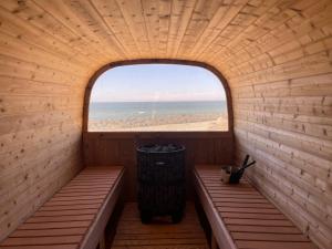 an empty sauna with a window and a trash can at Lønstrup Apartments, Klitrose in Lønstrup