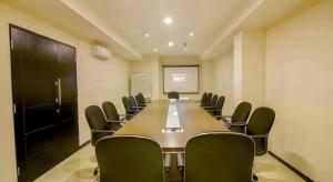 a conference room with a long table and chairs at Tab Hotel Surabaya in Surabaya