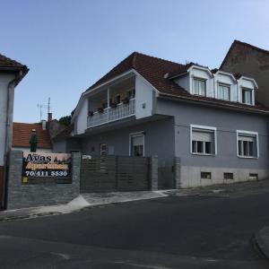 a white house with a balcony with people on it at Avas Apartman in Miskolc