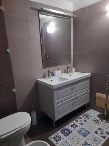 a bathroom with a sink and a toilet and a mirror at La casetta di Sofia in Torino