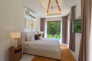 Ένα ή περισσότερα κρεβάτια σε δωμάτιο στο Phang nga Villas Private Pool & Tropical Retreats +121 φωτογραφίες
