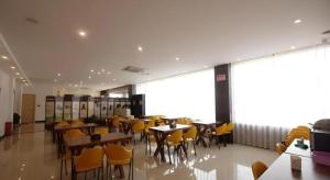 a dining room with tables and yellow chairs at Shell Nanjing City Qixia District Baguazhou Hotel in Nanjing
