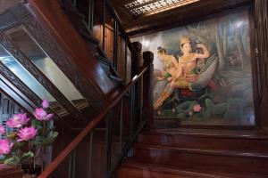 a painting on the wall in a room with stairs at True Siam Rangnam Hotel in Bangkok