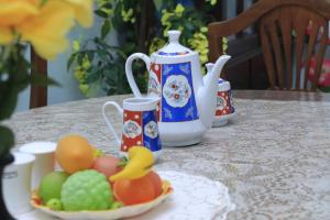 a table topped with cups and a bowl of fruit at Grindlays Villa in Weligama +43 photos