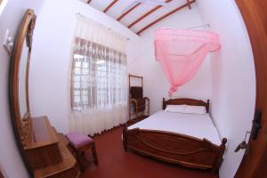 a bedroom with a bed and a mirror at Grindlays Villa in Weligama