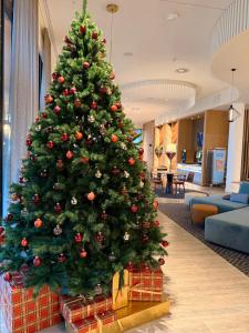 a christmas tree in a hotel lobby with a christmas tree at Hampton By Hilton Tallinn in Tallinn
