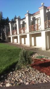 un gran edificio blanco con un patio con rocas en Poilsio namai Šaltinelis en Plateliai