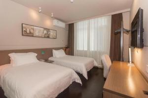 a hotel room with two beds and a flat screen tv at Jinjiang Inn Select Qingdao West Coast Coach Exhibition Center High-Speed Railway Station in Huangdao +210 photos