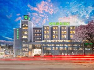 a large building with neon signs on top of it at GreenTree Inn Geermu Walking Street Business Hotel in Golmud