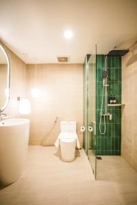 a bathroom with a shower and a toilet and a sink at Palma Hotel in Bangkok +33 photos