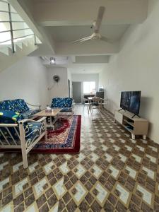 Una sala de estar con dos camas y un televisor. en Qaseh homestay, en Papar