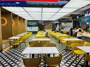 a restaurant with tables and chairs and people walking around at Max Suites At Barjaya Times Square Kl in Kuala Lumpur