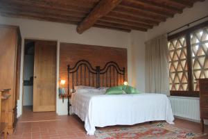 una camera con un grande letto e un muro di mattoni di Il Poggetto a Greve in Chianti