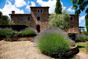 an old stone house with a garden in front of it at Il Poggetto in Greve in Chianti