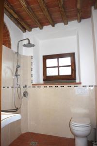 ein Badezimmer mit Toilette und Waschbecken und einem Fenster in der Unterkunft Il Poggetto in Greve in Chianti