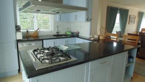 a kitchen with a stove and a counter top at Avocet Cottage in Knysna