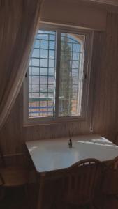 una ventana con un jarrón sobre una mesa en una habitación en شقق ڤيڤا - viva Apartments, en Amán