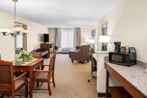 Comfort Suites Grandville - Grand Rapids SW في غراندفيل: غرفة في الفندق مع طاولة طعام وغرفة معيشة