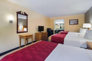 een hotelkamer met twee bedden en een spiegel bij Econo Lodge Battleboro - Rocky Mount I-95 in Battleboro +20 foto's