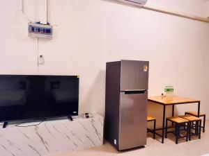 a large television and a table in a room at Phak Phing Hostel in Chiang Mai