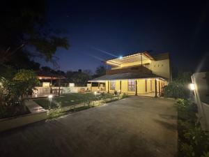 Una casa con luces encima por la noche. en Parijat Villa - A Perfect Weekend Getaway, en Pune