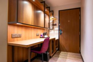 a kitchen with a desk and a purple chair at Aqueen Prestige Hotel Lavender in Singapore