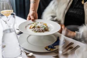 a person holding a plate of food on a table at Hotel Refsnes Gods - by Classic Norway Hotels in Moss