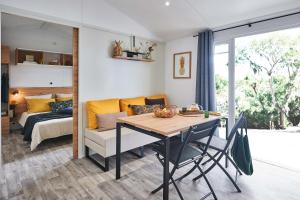 a dining room with a table and a bedroom at Camping Le Royan in Royan
