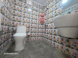 Un baño con inodoro y una pared de azulejos. en Studio One Room Bidiya Oman Sand Adventures Oasis استديو غرفة واحدة بدية عمان واحة المغامرات الرملية, en Badīyah